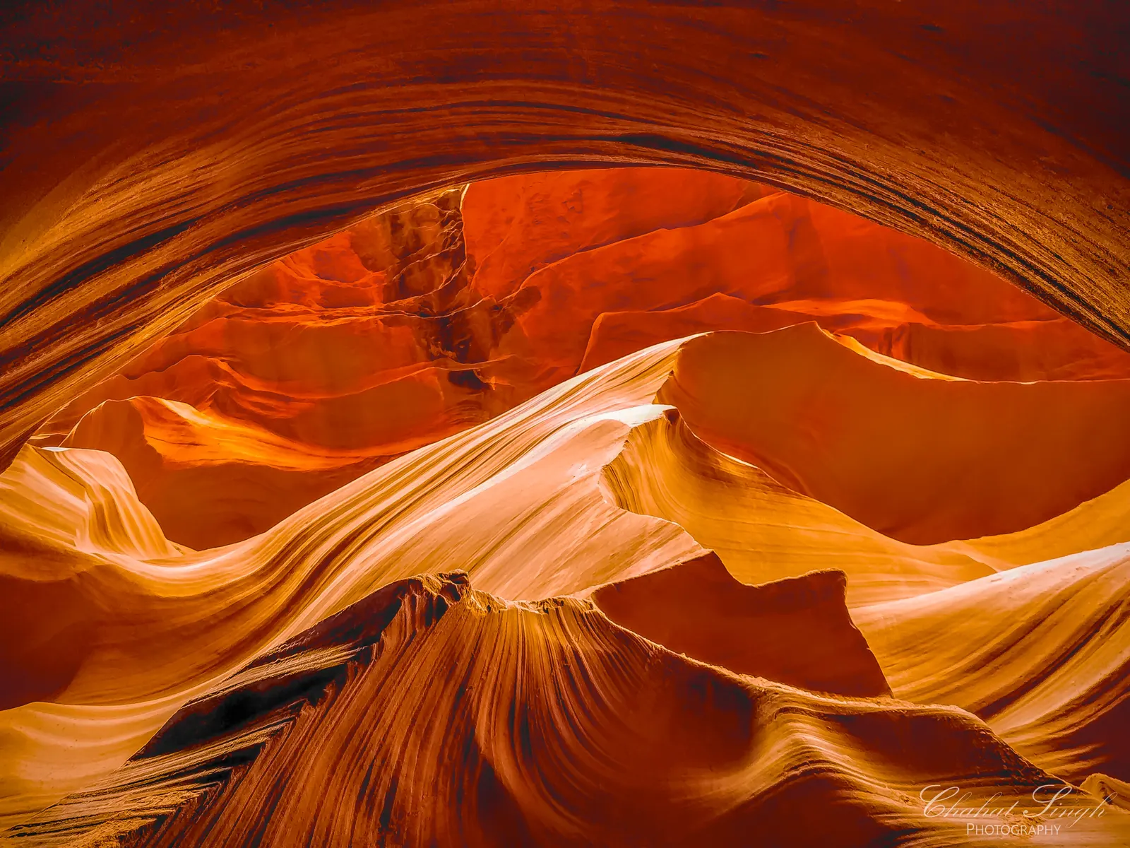 Swirling orange and purple sandstone walls in Antelope Canyon, forming abstract wave-like rock patterns.