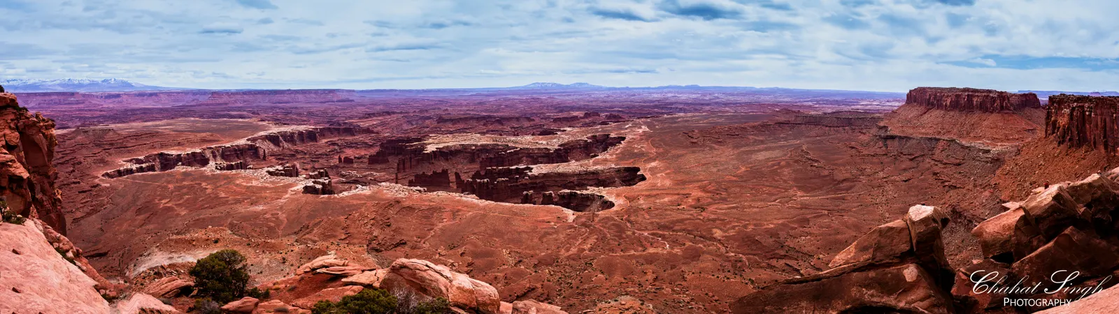 A sweeping panorama of red rock mesas and canyons stretching to the horizon at Canyonlands.